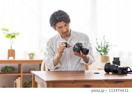 カメラの手入れをする男性 カメラの手入れをする男性 113474811