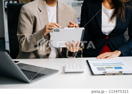 Businessman and team analyzing financial statement Finance task. with smart phone and laptop and  tablet. Wealth management concept. 113475321