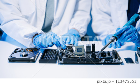 The technician is putting the CPU on the socket of the computer motherboard. electronic engineering electronic repair, electronics measuring. The technician is putting the CPU on the socket of the computer motherboard. electronic engineering electronic repair, electronics measuring. 113475353