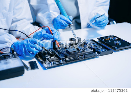 The technician is putting the CPU on the socket of the computer motherboard. electronic engineering electronic repair, electronics measuring. The technician is putting the CPU on the socket of the computer motherboard. electronic engineering electronic repair, electronics measuring. 113475361