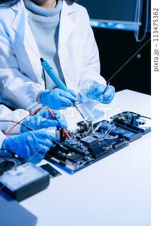 The technician is putting the CPU on the socket of the computer motherboard. electronic engineering electronic repair, electronics measuring. The technician is putting the CPU on the socket of the computer motherboard. electronic engineering electronic repair, electronics measuring. 113475362