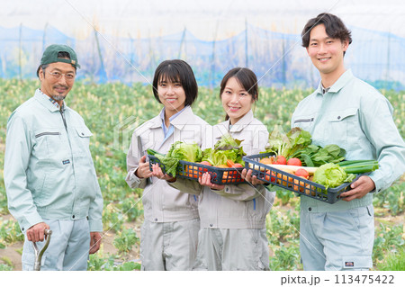農作物をかかえて笑顔を見せるベテラン農夫と若者たち 113475422