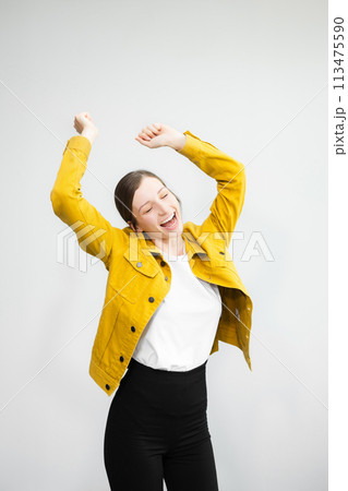 Young woman 20s wears casual clothes stand on toes dance lean back have fun spreading hands isolated on plain light white background studio portrait Young woman 20s wears casual clothes stand on toes dance lean back have fun spreading hands isolated on plain light white background studio portrait 113475590