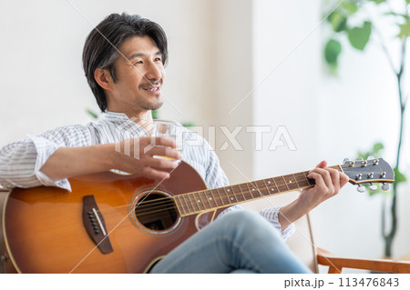 ギターを弾きながらお酒を楽しむ男性 113476843