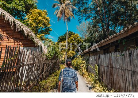 Woman walking on a small road on the island 113477775