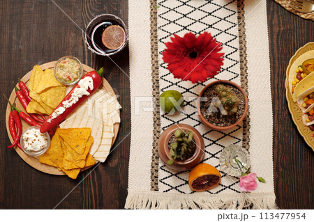 Festive table with snacks and flowers Festive table with snacks and flowers 113477954