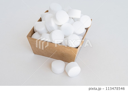 White tablets of pressed salt for the dishwasher close-up. Place for text 113478546