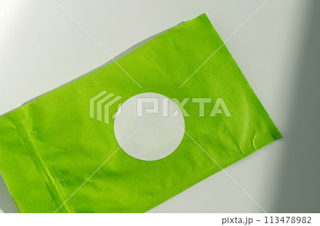 Round white sticker on green poly mailer envelope. 113478982