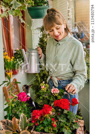 Woman Gardener Watering Plants at City Balcony 113480794