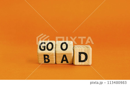 Good or bad symbol. Turned wooden cubes and changed the word bad to good. Beautiful orange table, orange background, copy space. Business and bad or good concept. 113480983