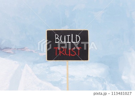 Build trust symbol. Concept words Build trust on beautiful yellow black blackboard. Beautiful blue ice background. Business and build trust concept, copy space. 113481027