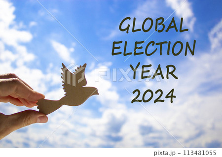 Global election year 2024 symbol. Concept words Global election year 2024. Beautiful blue sky cloud background. Voter hand with wooden bird. Business Global election year 2024 concept. Copy space Global election year 2024 symbol. Concept words Global election year 2024. Beautiful blue sky cloud background. Voter hand with wooden bird. Business Global election year 2024 concept. Copy space 113481055