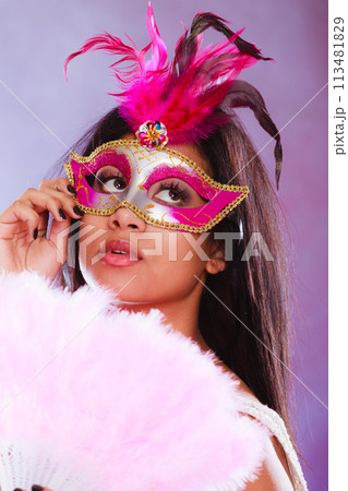 woman with carnival mask holds fan woman with carnival mask holds fan 113481829