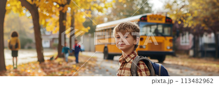 A Caucasian male schoolboy carrying a backpack is traveling on a school bus. 113482962