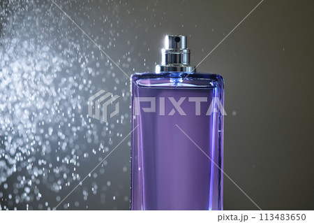 Perfume spray in a violet bottle on a dark background. Perfume spray in a violet bottle on a dark background. 113483650
