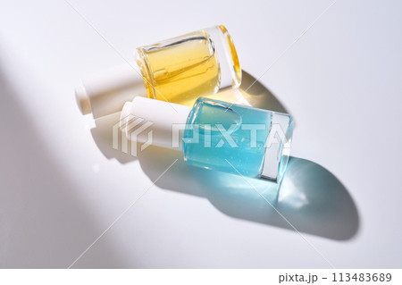 Yellow and blue serums with pipettes against the background of the sun. 113483689