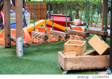 Empty playground with various equipment and toys on green synthetic grass 113484765