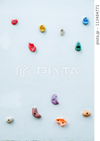Colorful climbing holds on wall for outdoor rock climbing 113484771
