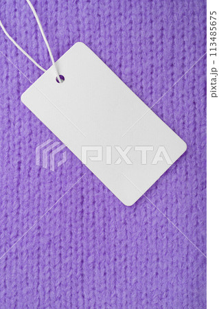 Template of blank clothing label, price tag on purple knitted sweater background 113485675