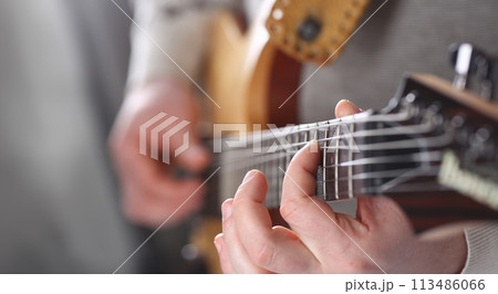 Male arms playing classic shape electric guitar 113486066