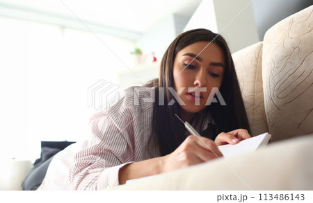 Smiling mellenial woman write story in 113486143