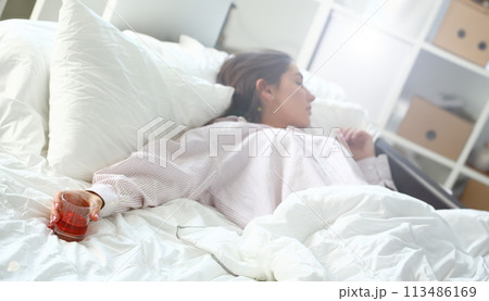 Young woman lying in bed deadly drunken Young woman lying in bed deadly drunken 113486169