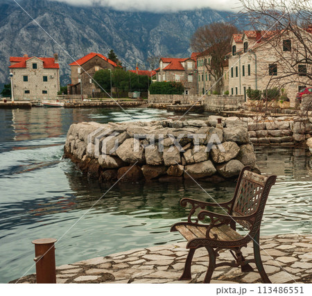 View of the Bay of Kotor and the mountains from the shore on a bench 113486551