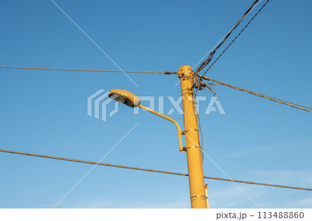 Streetlamp with cables and bright blue sky, Italy 113488860