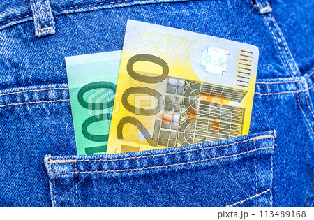 Euro banknotes sticking out of the back jeans pocket 113489168