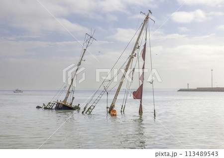 Picture of a sunken sailing yacht with masts sticking out of the water near Walvis Bay in Namibia 113489543