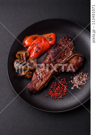 Delicious juicy beef tbone steak with salt, spices and herbs Delicious juicy beef tbone steak with salt, spices and herbs 113491071
