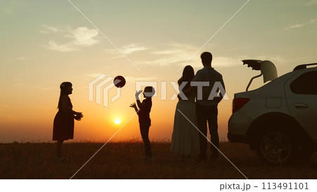 Family at sunset by car in field silhouettes. Children kids plays ball parents hugging enjoying romantic atmosphere happy moment. Importance of Spending Time Together Creating Lasting Family Memories Family at sunset by car in field silhouettes. Children kids plays ball parents hugging enjoying romantic atmosphere happy moment. Importance of Spending Time Together Creating Lasting Family Memories 113491101