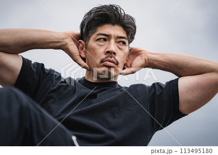 屋外で筋トレをする40代男性 113495180