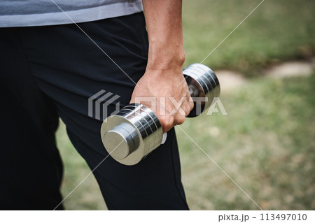 公園でダンベルで筋力トレーニングをする40代男性 113497010