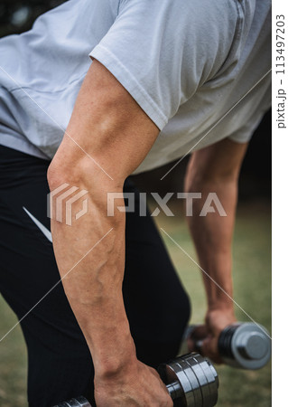 屋外でダンベルで筋トレをする男性 屋外でダンベルで筋トレをする男性 113497203