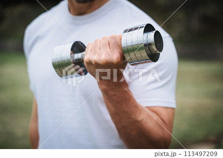 屋外でダンベルで筋トレをする男性 113497209
