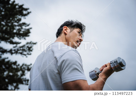 屋外でダンベルで筋トレをする男性 113497223