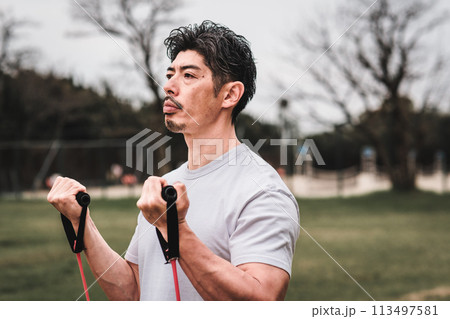 公園でトレーニングチューブで筋トレをする40代男性 公園でトレーニングチューブで筋トレをする40代男性 113497581