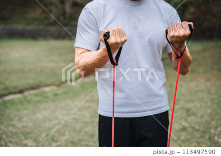 公園でトレーニングチューブで筋トレをする40代男性 公園でトレーニングチューブで筋トレをする40代男性 113497590