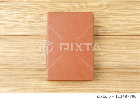 Brown notepad on a wooden background. Brown notepad on a wooden background. 113497796