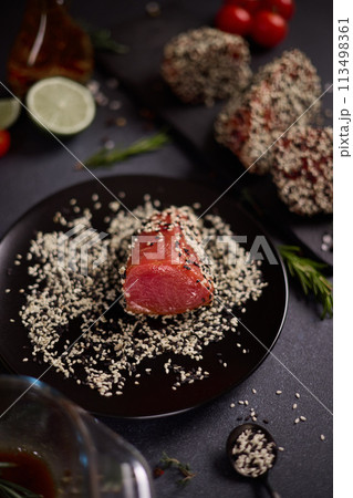piece of tuna fillet covered with sesame seeds before cooking piece of tuna fillet covered with sesame seeds before cooking 113498361