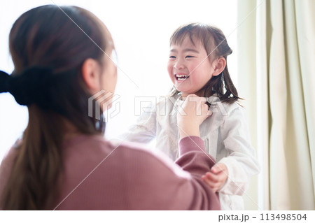 女の子の着替えを手伝うお母さん 女の子の着替えを手伝うお母さん 113498504