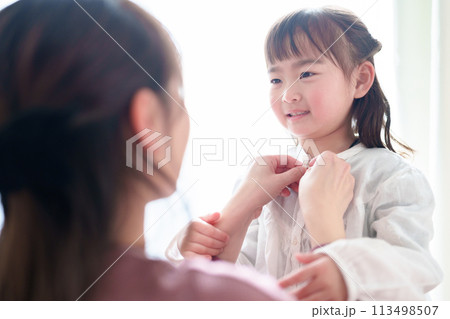 女の子の着替えを手伝うお母さん 113498507