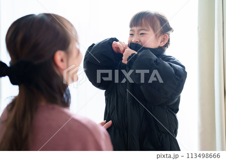 女の子の着替えを手伝うお母さん 113498666