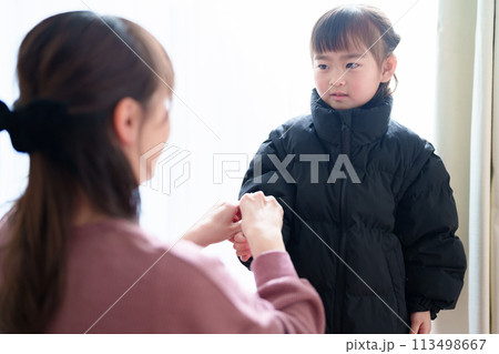 女の子の着替えを手伝うお母さん 女の子の着替えを手伝うお母さん 113498667