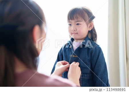 女の子の着替えを手伝うお母さん 女の子の着替えを手伝うお母さん 113498691