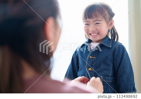 女の子の着替えを手伝うお母さん 113498692