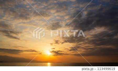 夕方の空に沈んでいく夕陽と、たくさんの雲 夕方の空に沈んでいく夕陽と、たくさんの雲 113499619