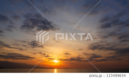 夕方の空に沈んでいく夕陽と、たくさんの雲 夕方の空に沈んでいく夕陽と、たくさんの雲 113499634
