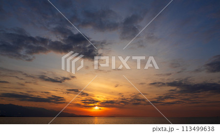 夕方の空に沈んでいく夕陽と、たくさんの雲 夕方の空に沈んでいく夕陽と、たくさんの雲 113499638